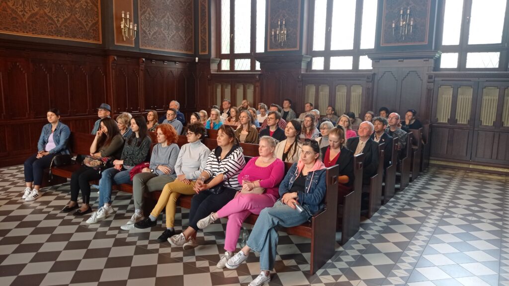 Uczestnicy wykładu siedzą w długich ławach na sali rozpraw w Sądzie Rejonowym w Raciborzu